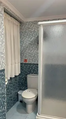 a bathroom with a toilet and a glass shower door at Luz Baal Grupo AC Gestion in Cádiz