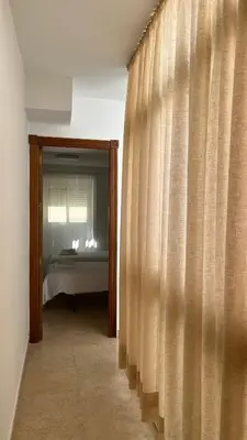 a room with a bed and a window with curtains at Luz Baal Grupo AC Gestion in Cádiz