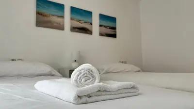 a white towel sitting on top of a bed at Luz Baal Grupo AC Gestion in Cádiz