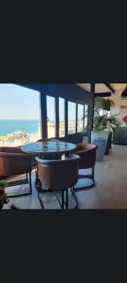 a table and chairs on a balcony with a view of the ocean at El vigía de cadiz in Cádiz