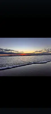 a view of a beach with the ocean at sunset at El vigía de cadiz in Cádiz