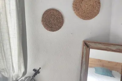 a mirror and two baskets on a wall at Charming apartment in Arcos de la Frontera, 70 m² with balcony in Arcos de la Frontera