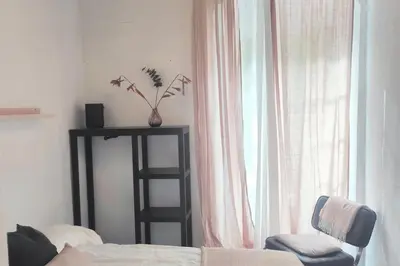 a bedroom with a bed and a chair and a window at Charming apartment in Arcos de la Frontera, 70 m² with balcony in Arcos de la Frontera