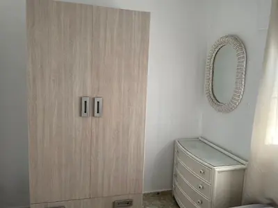 a bathroom with a wooden cabinet and a mirror at Villa Irina in Chiclana de la Frontera