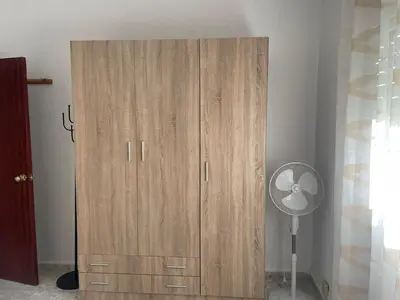 a wooden cabinet with a fan in a room at Villa Irina in Chiclana de la Frontera