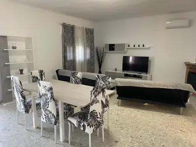 a living room with a table and chairs and a television at Villa Irina in Chiclana de la Frontera
