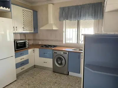 a kitchen with a washing machine and a microwave at Villa Irina in Chiclana de la Frontera