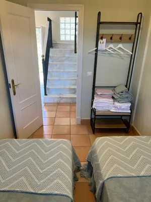 a room with two beds and a staircase with a stair case at Casa piscina playa Barrosa Delfin 7 in Chiclana de la Frontera