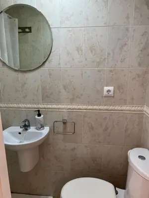 a bathroom with a sink and a toilet and a mirror at Casa piscina playa Barrosa Delfin 7 in Chiclana de la Frontera