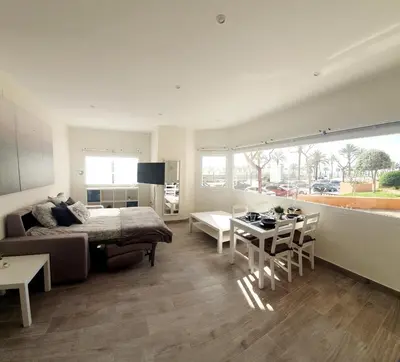 a bedroom with a bed and a table and a dining room at Playa Doñana 1 in Sanlúcar de Barrameda