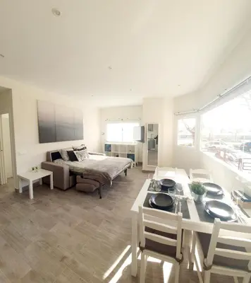 a living room with a bed and a table with chairs at Playa Doñana 1 in Sanlúcar de Barrameda