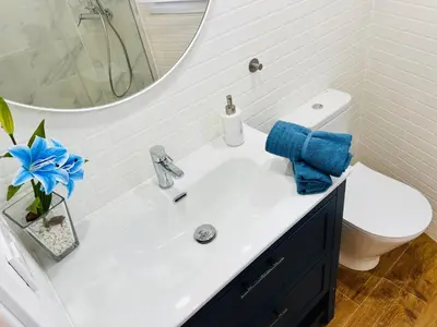 a bathroom with a sink and a toilet and a mirror at Villa Horacia - Playa de la Jara con Piscina in Sanlúcar de Barrameda