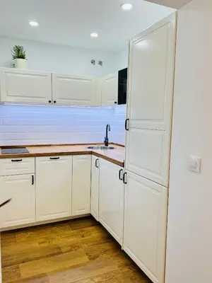 a kitchen with white cabinets and a white refrigerator at Villa Horacia - Playa de la Jara con Piscina in Sanlúcar de Barrameda