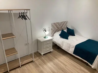 a bedroom with a bed and a lamp on a night stand at La Casa de la Fuente in Sanlúcar de Barrameda