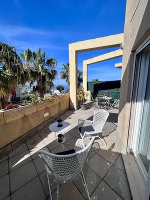 a patio with chairs and a table on a balcony at GATU Villa Atardecer en la playa de las Redes 