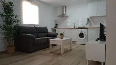 a living room with a couch and a washing machine at Apartamento La Saeta in Jerez de la Frontera