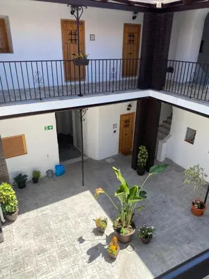 an empty courtyard with potted plants in a building at Apartamento AstaRegia in Jerez de la Frontera