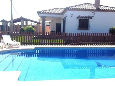 a swimming pool in front of a house at CASA VARAVILLA in Conil de la Frontera