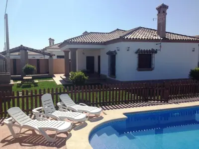 a group of chairs sitting next to a swimming pool at CASA VARAVILLA in Conil de la Frontera