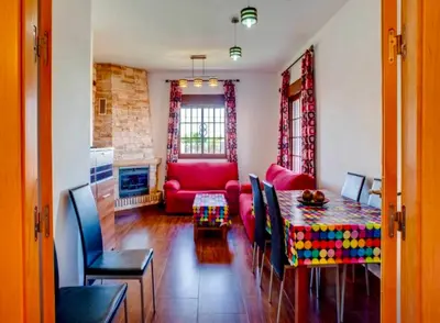 a living room with a table and a red couch at CASA VARAVILLA in Conil de la Frontera