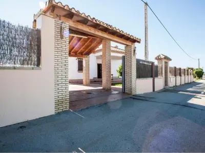 a white house with a wooden pergola at CASA VARAVILLA in Conil de la Frontera