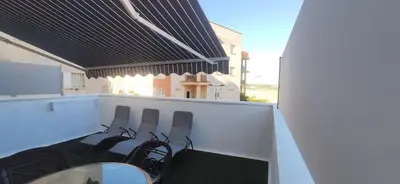 a balcony with chairs and a table and a mirror at JT CHICLANA, ,Parking, Aire, Wifi, TV, Terraza in Chiclana de la Frontera