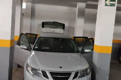 a white car parked in a parking garage with a luggage rack on the roof at JT CHICLANA, ,Parking, Aire, Wifi, TV, Terraza in Chiclana de la Frontera
