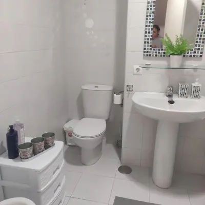 a white bathroom with a toilet and a sink at JT CHICLANA, ,Parking, Aire, Wifi, TV, Terraza in Chiclana de la Frontera