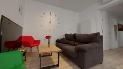 a living room with a couch and a clock on the wall at LA VICTORIA in Cádiz