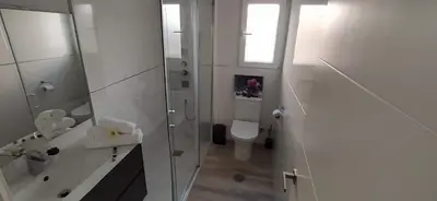 a white bathroom with a toilet and a shower at LA VICTORIA in Cádiz