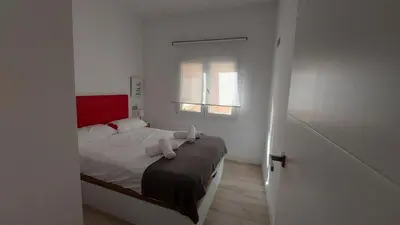 a bedroom with a bed with two towels on it at LA VICTORIA in Cádiz