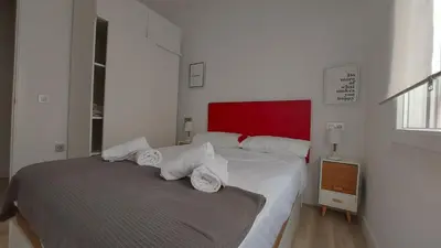a bedroom with a large bed with a red headboard at LA VICTORIA in Cádiz