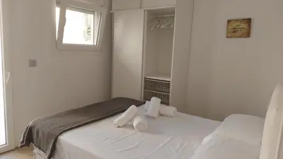 a white bedroom with a bed with towels on it at LA VICTORIA in Cádiz
