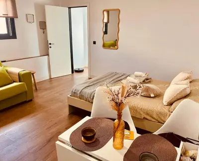 a living room with a bed and a table with a table sidx sidx at Loft céntrico con gran terraza in El Puerto de Santa María