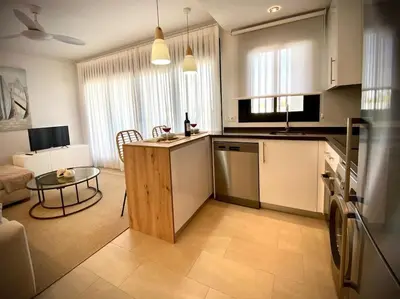 a kitchen and a living room with a table and a counter at MyChoice Terraces in Rota