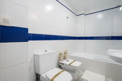 a white bathroom with a toilet and a sink at Apartoyou - Vistahermosa in El Puerto de Santa María