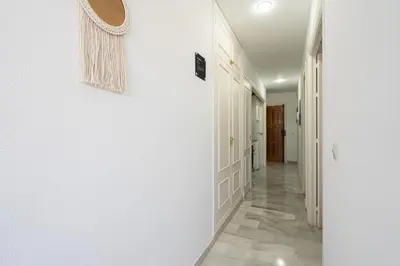 a hallway with white walls and a mirror on the wall at Apartoyou - Vistahermosa in El Puerto de Santa María