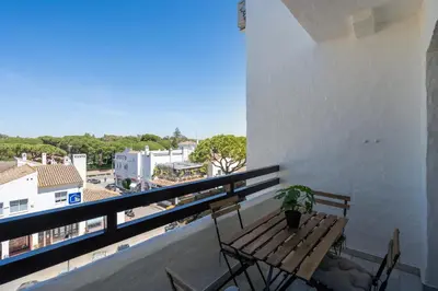 a balcony with a wooden bench and a table at Apartoyou - Vistahermosa in El Puerto de Santa María