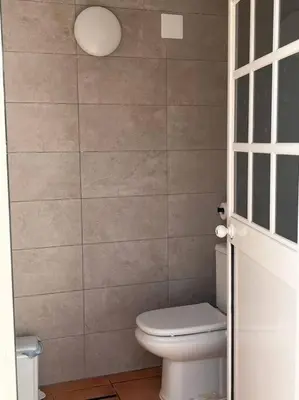 a bathroom with a toilet and a wall at Villa Armonía in Arcos de la Frontera