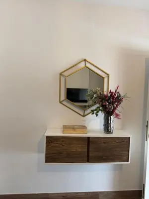 a mirror on a wall with a vase of flowers at Villa Armonía in Arcos de la Frontera