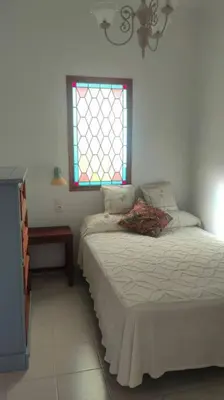 a bedroom with a bed and a window at Casa Las Vidrieras in Puerto Real