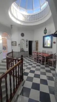 a room with a checkered floor and a dining room at Casa Las Vidrieras in Puerto Real