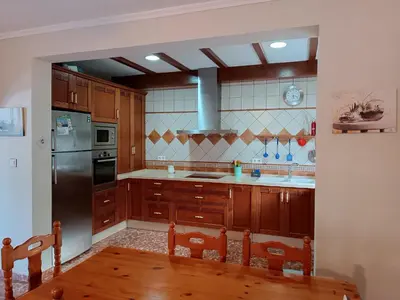 a kitchen with wooden cabinets and a stainless steel refrigerator at Las Salinas in Chiclana de la Frontera