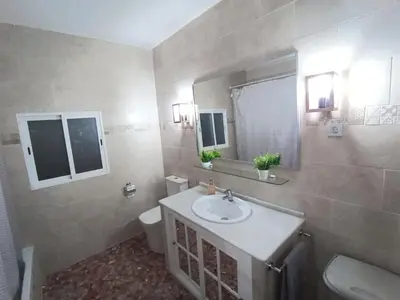 a bathroom with a sink and a toilet and a mirror at Las Salinas in Chiclana de la Frontera