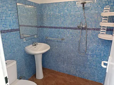 a blue tiled bathroom with a sink and a shower at Las Salinas in Chiclana de la Frontera