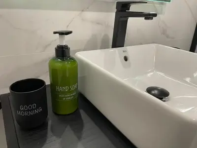 a green bottle of hand soap sitting next to a sink at Skyline - Loft with private terrace and breathtaking views! in Cádiz