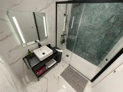 a bathroom with a shower and a sink and a mirror at Skyline - Loft with private terrace and breathtaking views! in Cádiz