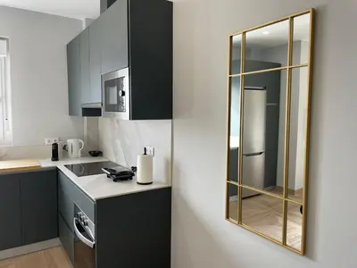a kitchen with black and white cabinets and a mirror at Skyline - Loft with private terrace and breathtaking views! in Cádiz