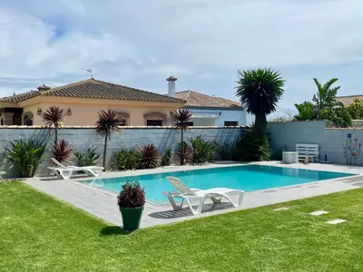 a swimming pool in the yard of a house at Villa Árbol del Tule in Chiclana de la Frontera