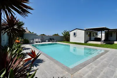 a swimming pool in the backyard of a house at Villa Árbol del Tule in Chiclana de la Frontera